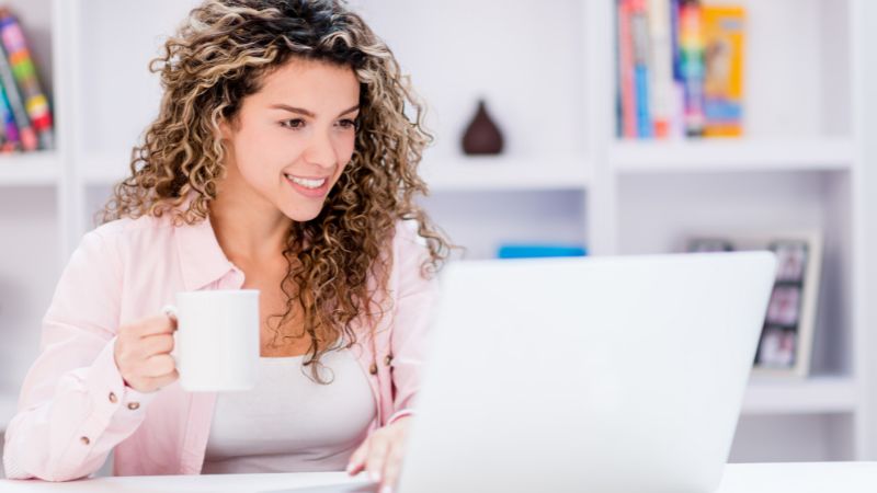 junge Frau arbeitet am Schreibtisch mit ihrem Laptop