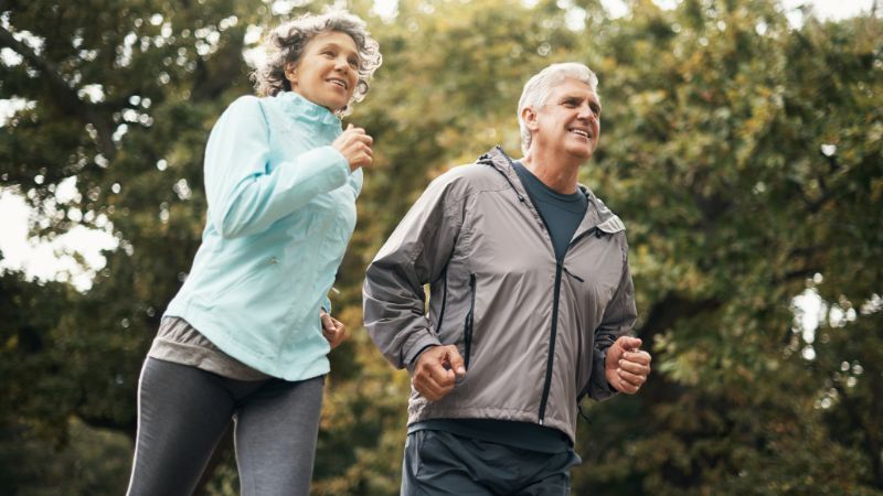 älteres pärchen joggt durch den park