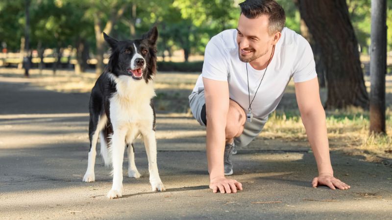 mann mit hund in ausgangsposition für den start zum lauftraining