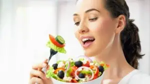 junge frau ist aus einer bunten salatschüssel